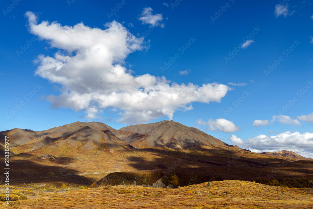 Clouds over a peak on a tundra landscape with dramatic lighting with shadows at Denali National Park, Alaska