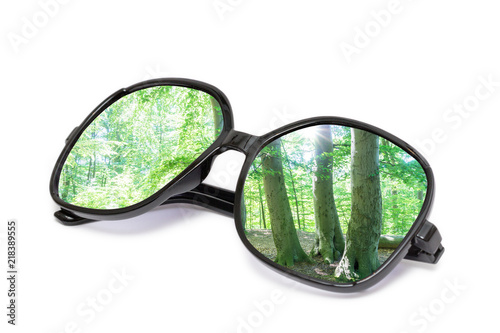 Schwarze Sonnenbrille mit Wald Reflektion in den Gläsern auf weißem Hintergrund isoliert