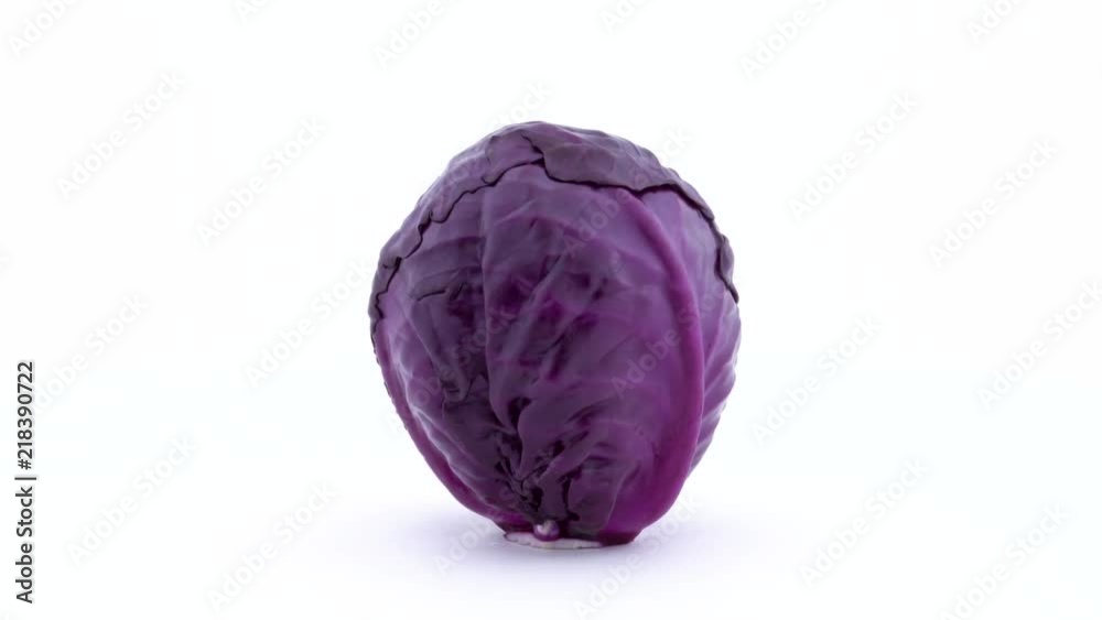 One whole mini purple cabbage is rotating on the turntable isolated on the white background. Close-up. Macro. One whole mini purple cabbage is rotating on the turntable isolated on the white background. Close-up. Macro.
