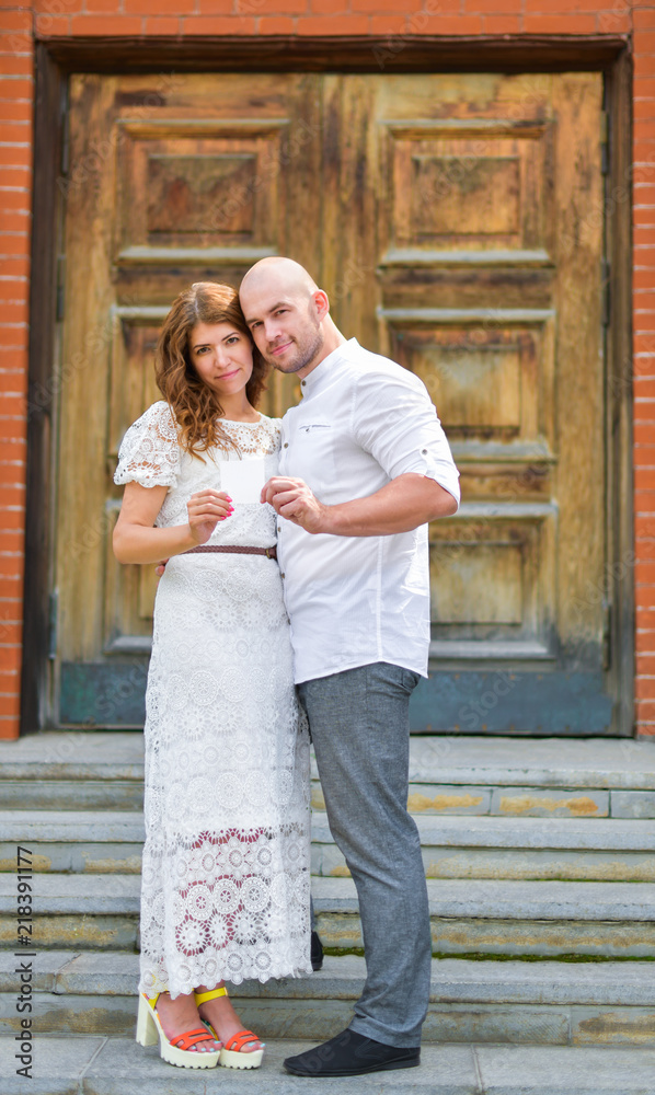 Cute couple holding. in front of a blank piece of paper. Cute couple holding. in front of a blank piece of paper.