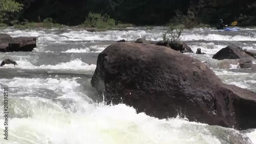 Big boulder, rushing river and a passing kayaker