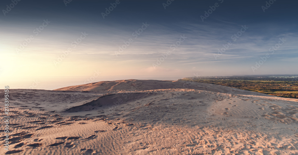 Epic and dramatic sunset light of the ocean and sand dunes cliff. Rubjerg Knude Lighthouse, Lønstrup in North Jutland in Denmark, Skagerrak, North Sea