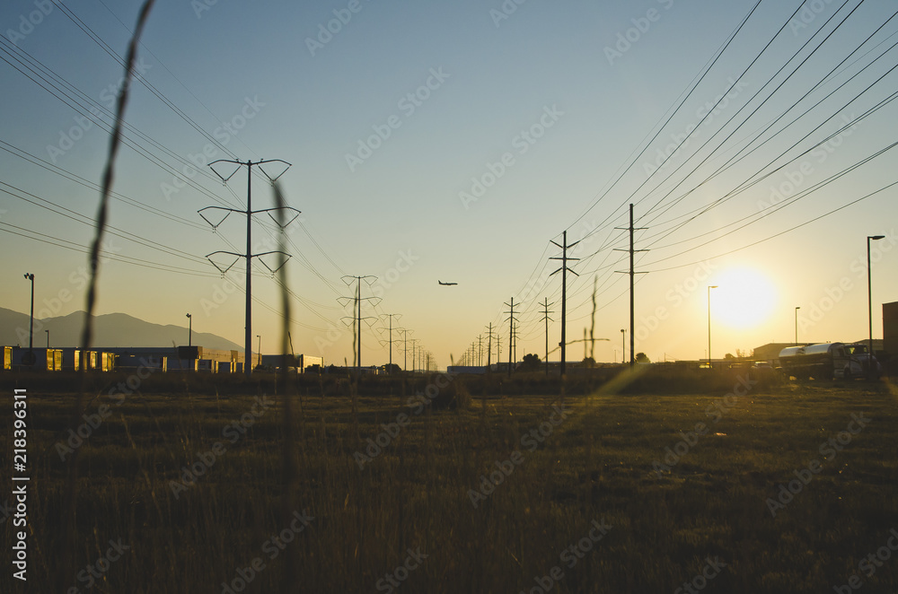 The solo planing flying over the warehouses and power lines in the evening sun. 
