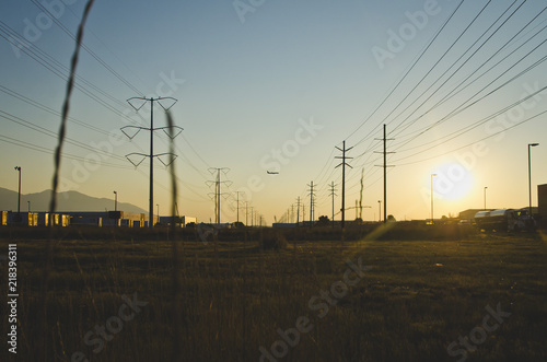 The solo planing flying over the warehouses and power lines in the evening sun. 