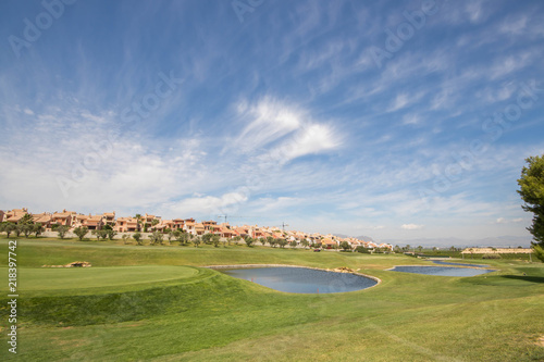 Green, lakes and luxury houses at a golf course on the Costa Blanca on a sunny summer day in Spain