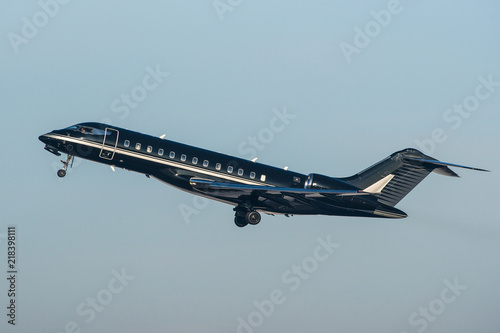 Black modern private business jet taking off
