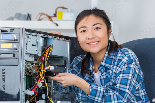 woman repairing an electronic component of a computer