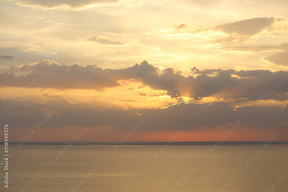Beautiful sunset with clouds of orange and yellow in the ocean, the river