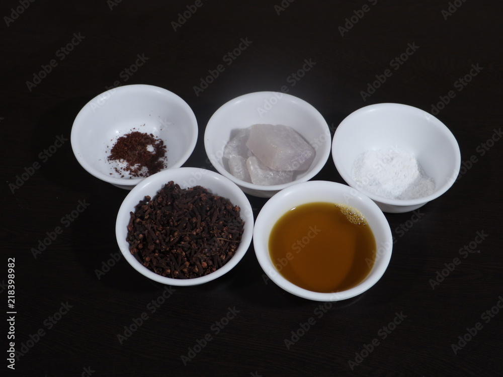 Alum Clove and Mustard Oil in white bowl on wooden background, Fitkari Powder on Wooden Background, Whole Clove and Whole Alum and Clove Powder and Alum powder on wooden background, Mustard Oil Alum Clove and Mustard Oil in white bowl on wooden background, Fitkari Powder on Wooden Background, Whole Clove and Whole Alum and Clove Powder and Alum powder on wooden background, Mustard Oil