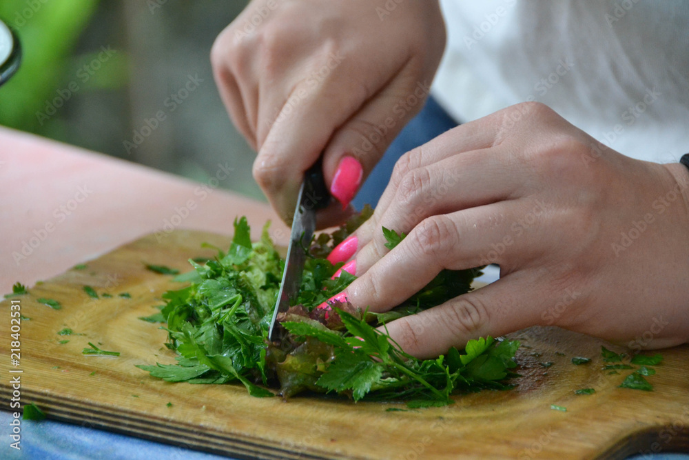 Chef cuts the vegetables into a meal. A woman uses a knife and cooks. Chef cuts the vegetables into a meal. A woman uses a knife and cooks.