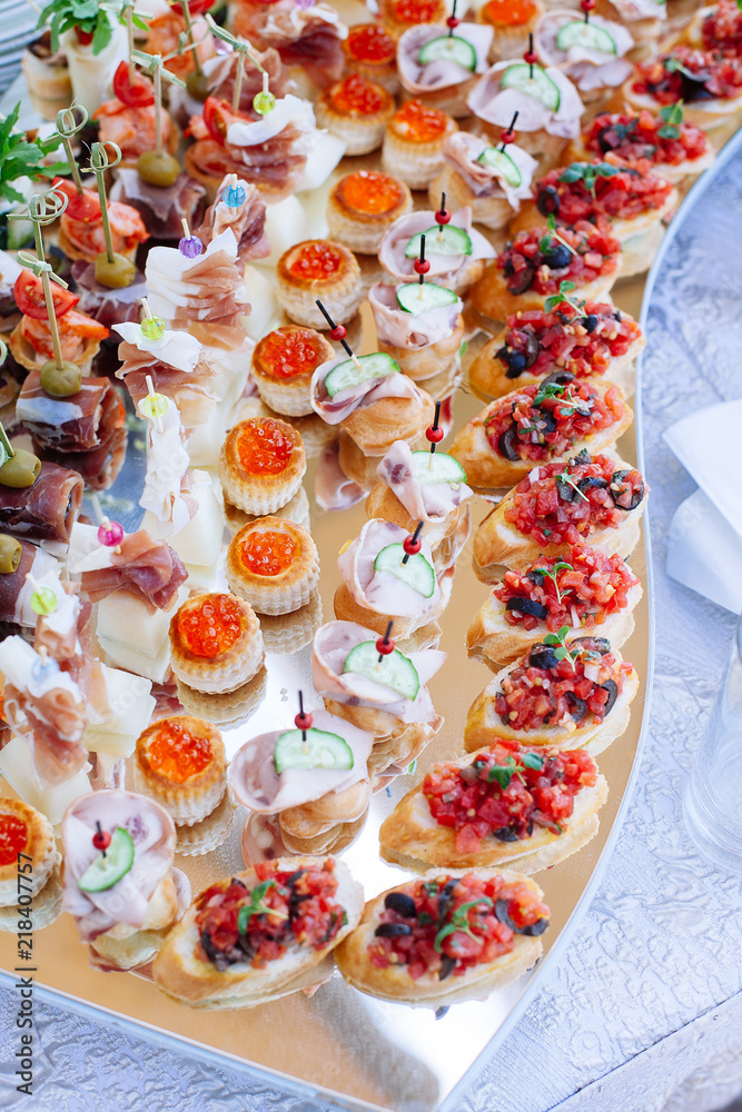 Fototapeta premium Beautifully decorated catering banquet with different food snacks and appetizers