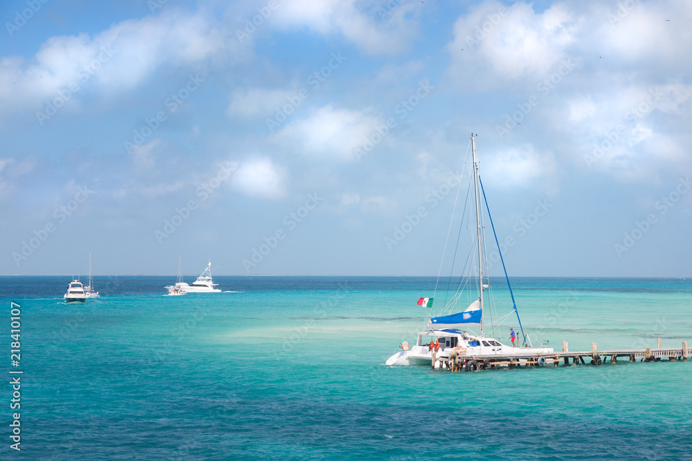 Obraz premium A catamaran and other boat near the shore on Isla Mujeres, Mexico.