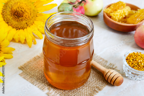 Honey in a glass jar, honeycomb, pollen. Products of beekeeping. The concept of healthy eating. Honey theme.