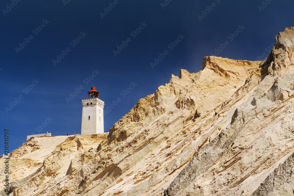 Sand cliffs and sand dunes with the famous lighthouse seen from the danish beach. Rubjerg Knude Lighthouse, Lønstrup and Lokken in North Jutland in Denmark, Skagerrak, North Sea