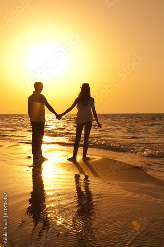 Romantic pair holding hands in the hot sunset