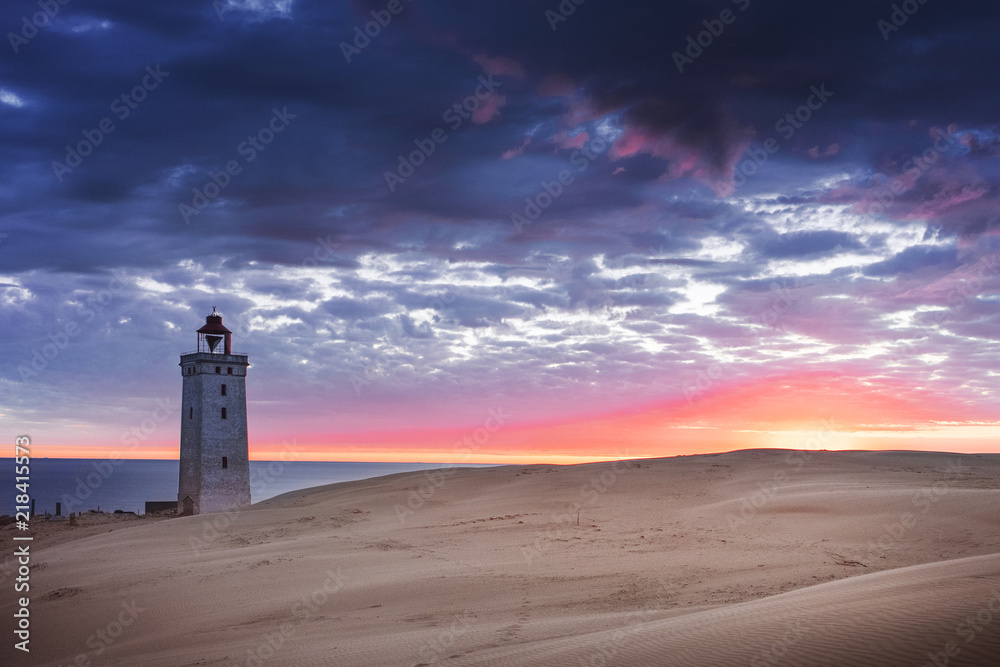 Colorful scene of the lighthouse and dunes in the sunset and dramatic moody sky. Rubjerg Knude Lighthouse, Lønstrup in North Jutland in Denmark, Skagerrak, North Sea