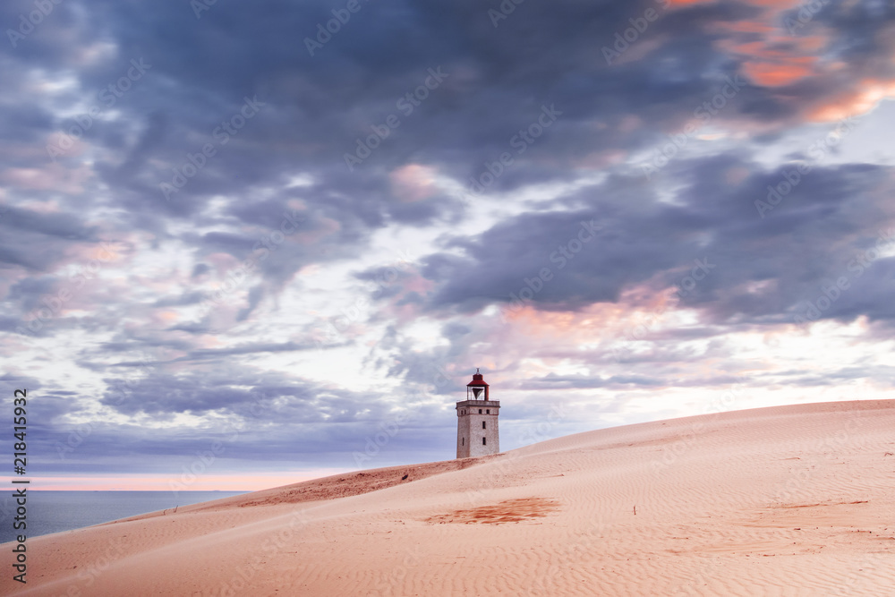 Danish coastline with sand dunes landscape at a dramatic colorful dawn morning sunrise with the ocean. Rubjerg Knude Lighthouse, Lønstrup in North Jutland in Denmark, Skagerrak, North Sea