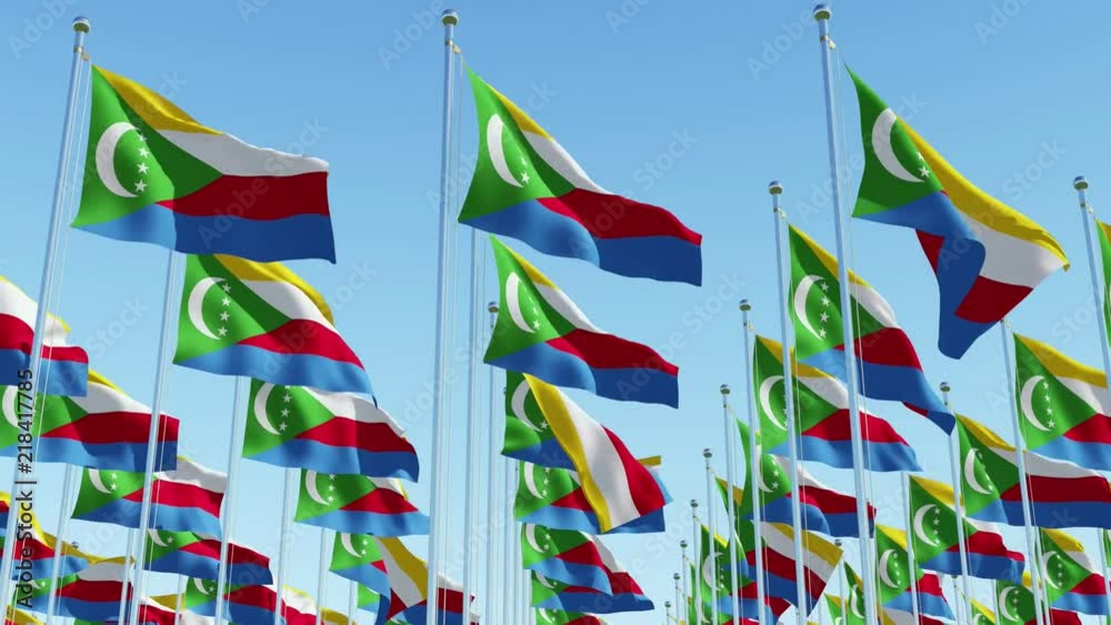 Many Comoros flags waving on the wind in a row against blue sky. Three dimensional rendering animation. Many Comoros flags waving on the wind in a row against blue sky. Three dimensional rendering animation.