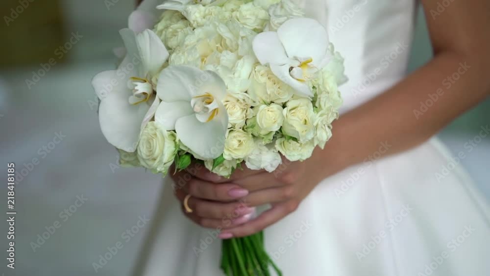 Bride holding bouquet with white rose flowers indoors Bride holding bouquet with white rose flowers indoors