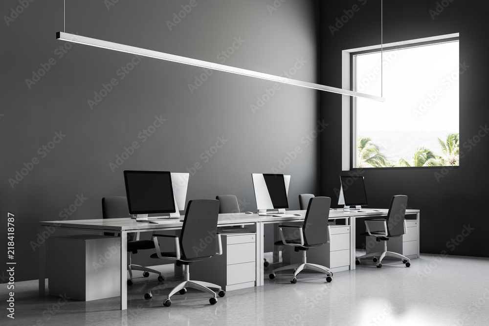 Row of computer desks in gray office side view