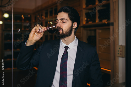 Young sommelier testing wines in winery.