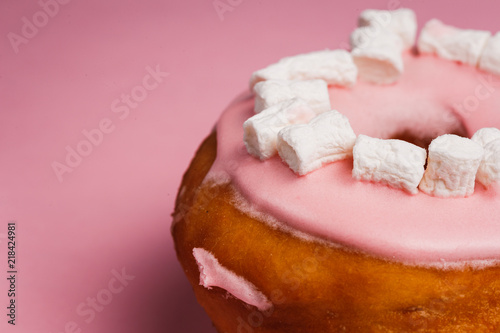 Pink donut with marshmallows on a Pink background