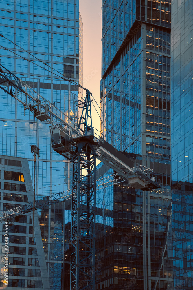 Crane construction bricks concrete building in city downtown skyscrapers