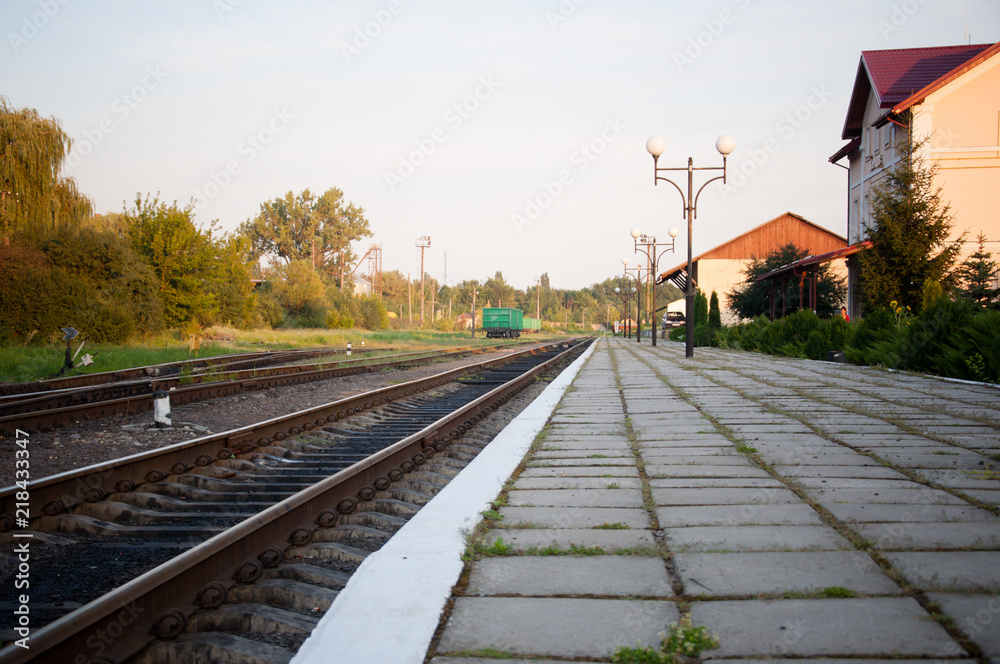 railway tracks lead to the station on a summer