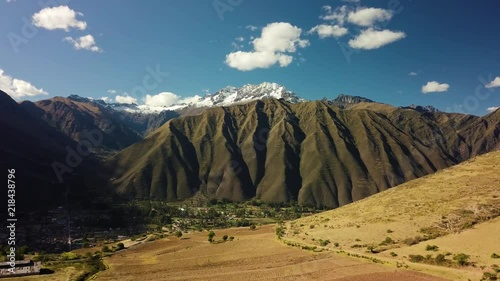 Peru Sacred Valley aerial push-in towards snow-capped peak of El Chicon and town of Urubamba. UHD photo