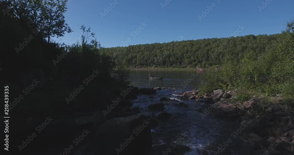 Flyfishing on a boat in a large river in the nature Flyfishing on a boat in a large river in the nature