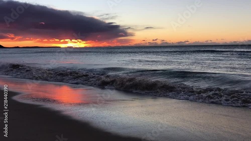 Small waves washing up on the beach at sunrise photo