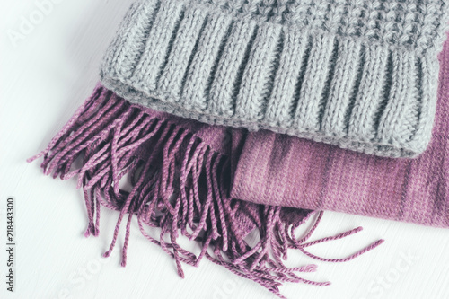 Gray woolen knitted hat and pink scarf on a white background