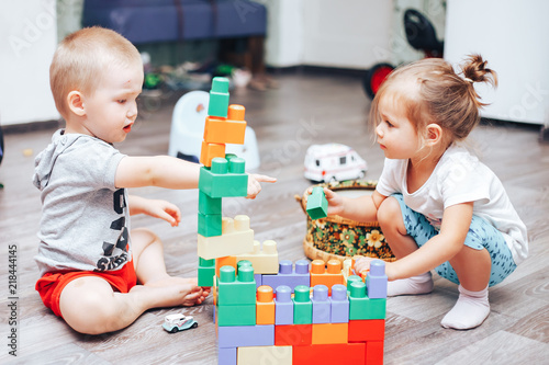 little boy and girl playing toys at home