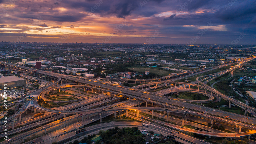 Fototapeta premium Aerial view highway road intersection at dusk for transportation, distribution or traffic background.