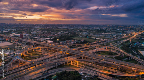 Aerial view highway road intersection at dusk for transportation, distribution or traffic background. © Pawinee