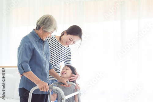 Portrait of happy senior woman walking with walker with her family at home