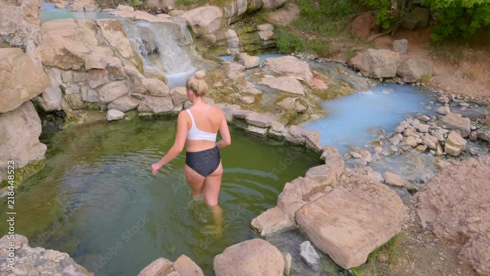 Blonde girl getting into green hot spring then strikes a pose and has fun Blonde girl getting into green hot spring then strikes a pose and has fun