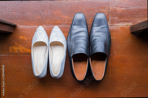 Top view of white high heels and men's shoes on wooden background.Lovers' shoes.Wedding