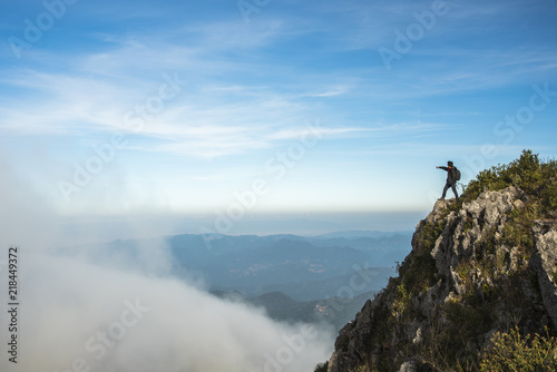 Man on rock , mist and mountains view