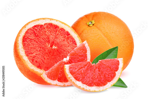 whole and slices red grapefruit with green leaves isolated on white background