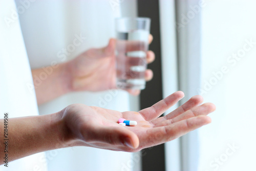 a lot of colored pills and a glass of water in the hands of men. health concept