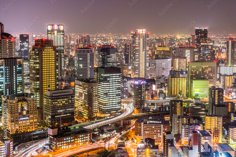 Fototapeta premium Osaka cityscapes with long traffic light trails at night. Scenery from Kuchu Teien Observatory on Umeda Sky Building.