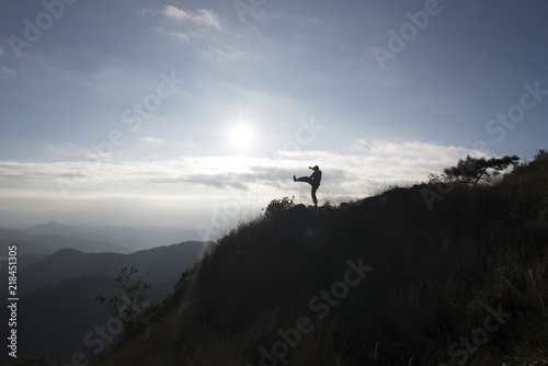 Silhouette of a man jumping on top mountain