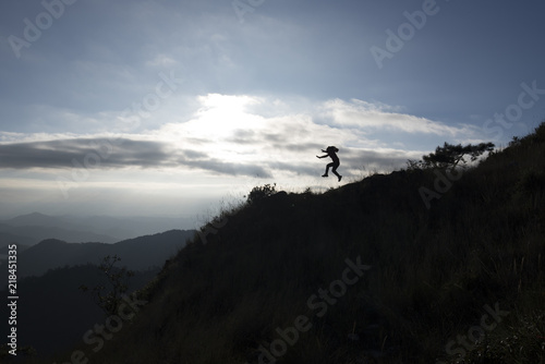 Silhouette of a woman jumping on top mountain © Eak Ekkachai