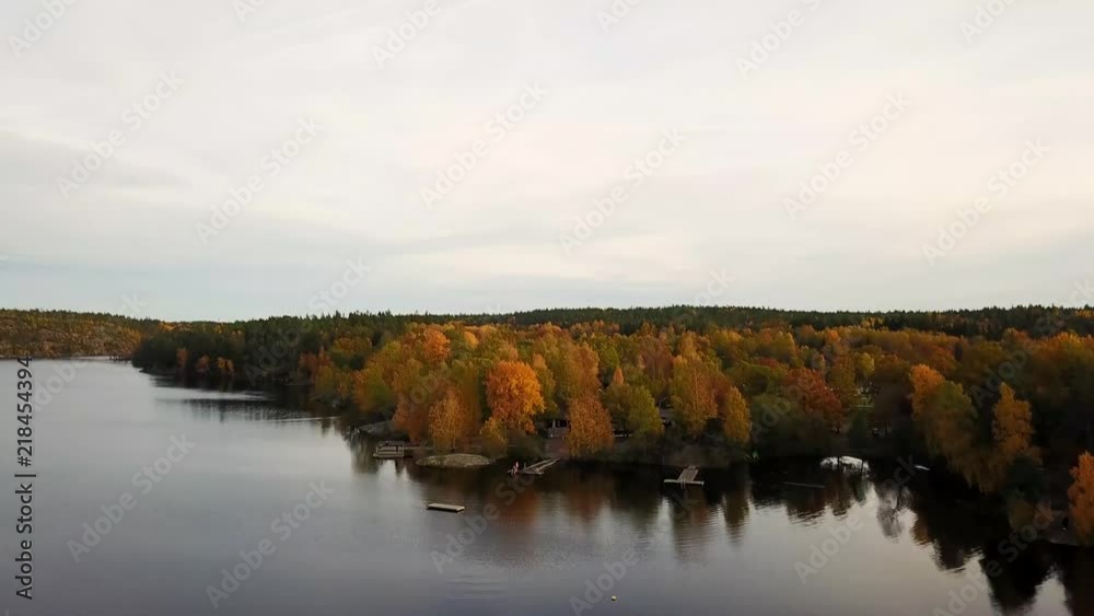Drone flies over lake and colourful trees in the autoumn in sweden Drone flies over lake and colourful trees in the autoumn in sweden