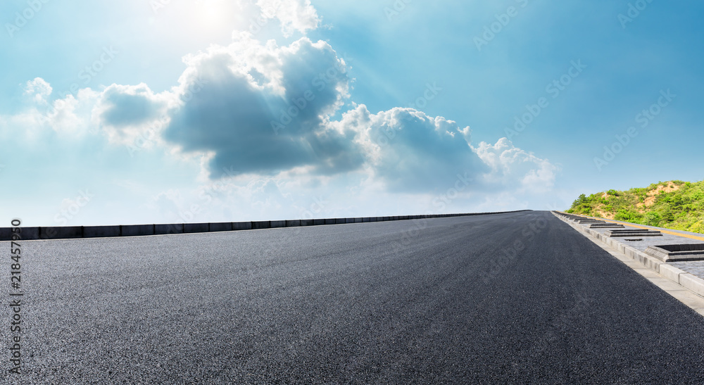 Fototapeta premium Empty asphalt road and mountain scenery under the blue sky