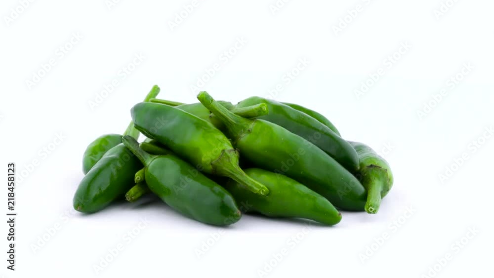 Heap of small green piri-piri chili peppers. Rotating on the turntable. Isolated on the white background. Close-up. Macro. Heap of small green piri-piri chili peppers. Rotating on the turntable. Isolated on the white background. Close-up. Macro.