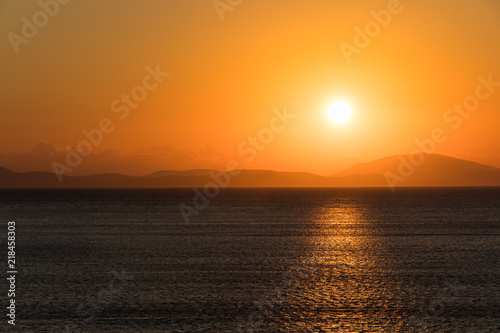 Sunrise over the sea and mountains on the horizon. © Evgheni