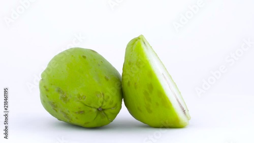 One whole and one half of chayote fruit. Rotating on the turntable. Isolated on the white background. Close-up. Macro. photo