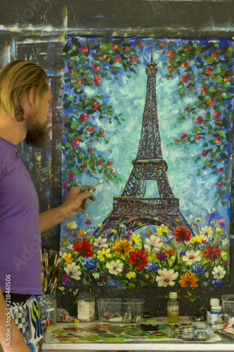 Artist male painter paiint in studio Eiffel Tower, Paris on a blue background handmade palette knife oil painting. Romantic Eiffel Tower artwork illustration photo